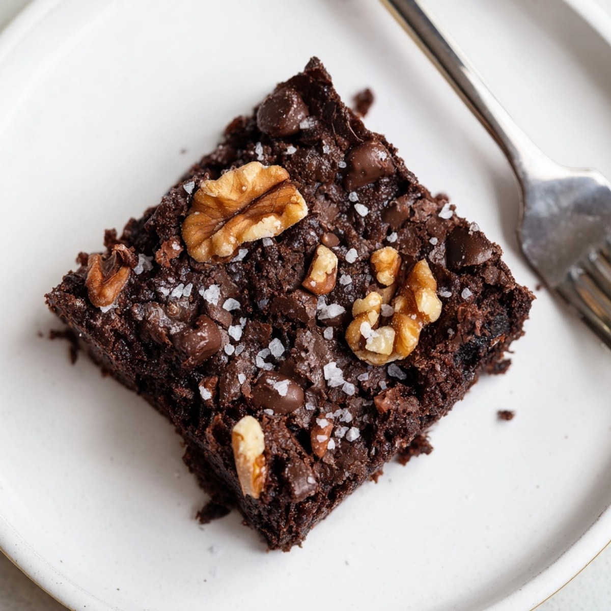 Golden-edged Almond Flour Brownies, served on a plate with vanilla ice cream; easy recipe.