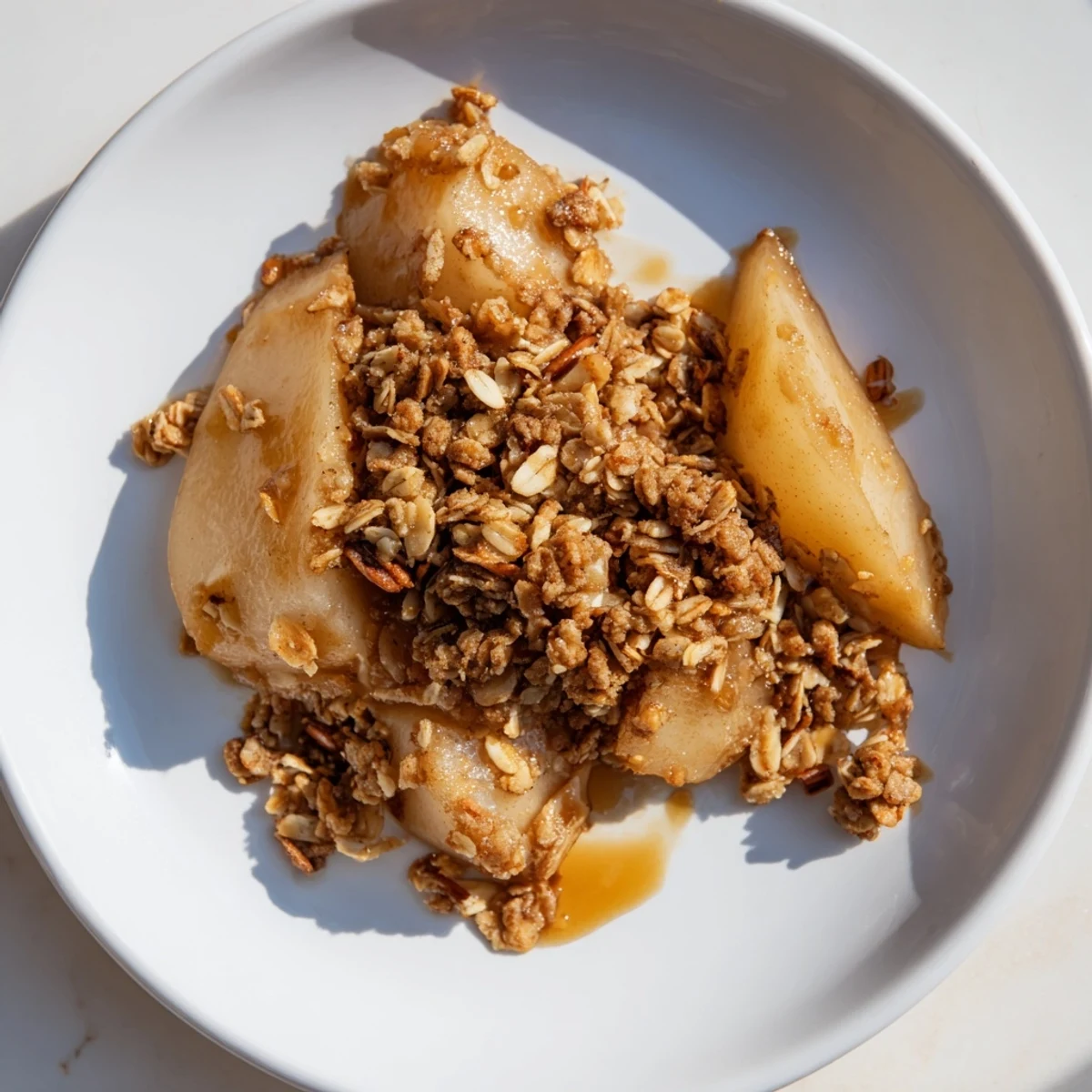 A close-up of a rustic Pear Almond Crumble; the crumble topping and glaze are irresistible.