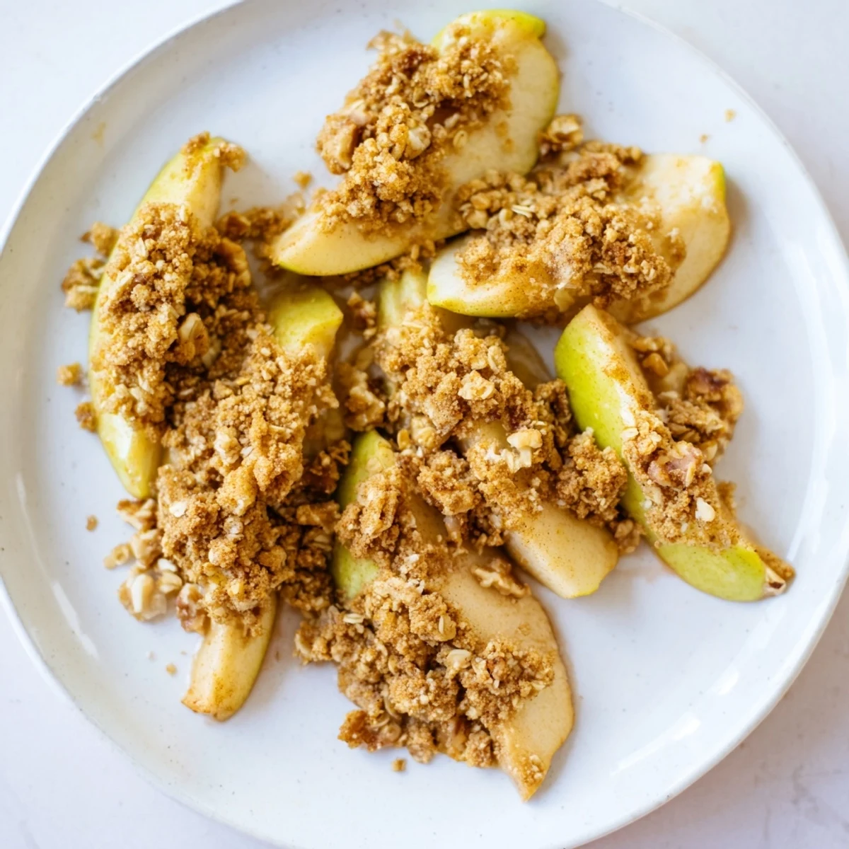 Warm, spiced Baked Toasted Cinnamon Apples with a golden oat crumble, ready to serve with ice cream.