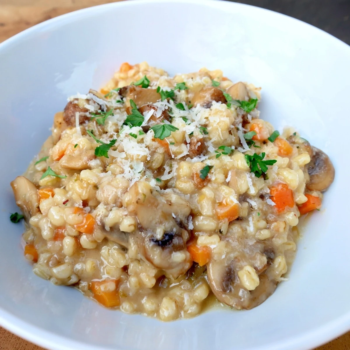 A close-up of the delicious barley and mushroom risotto, garnished with fresh parsley and cheese.