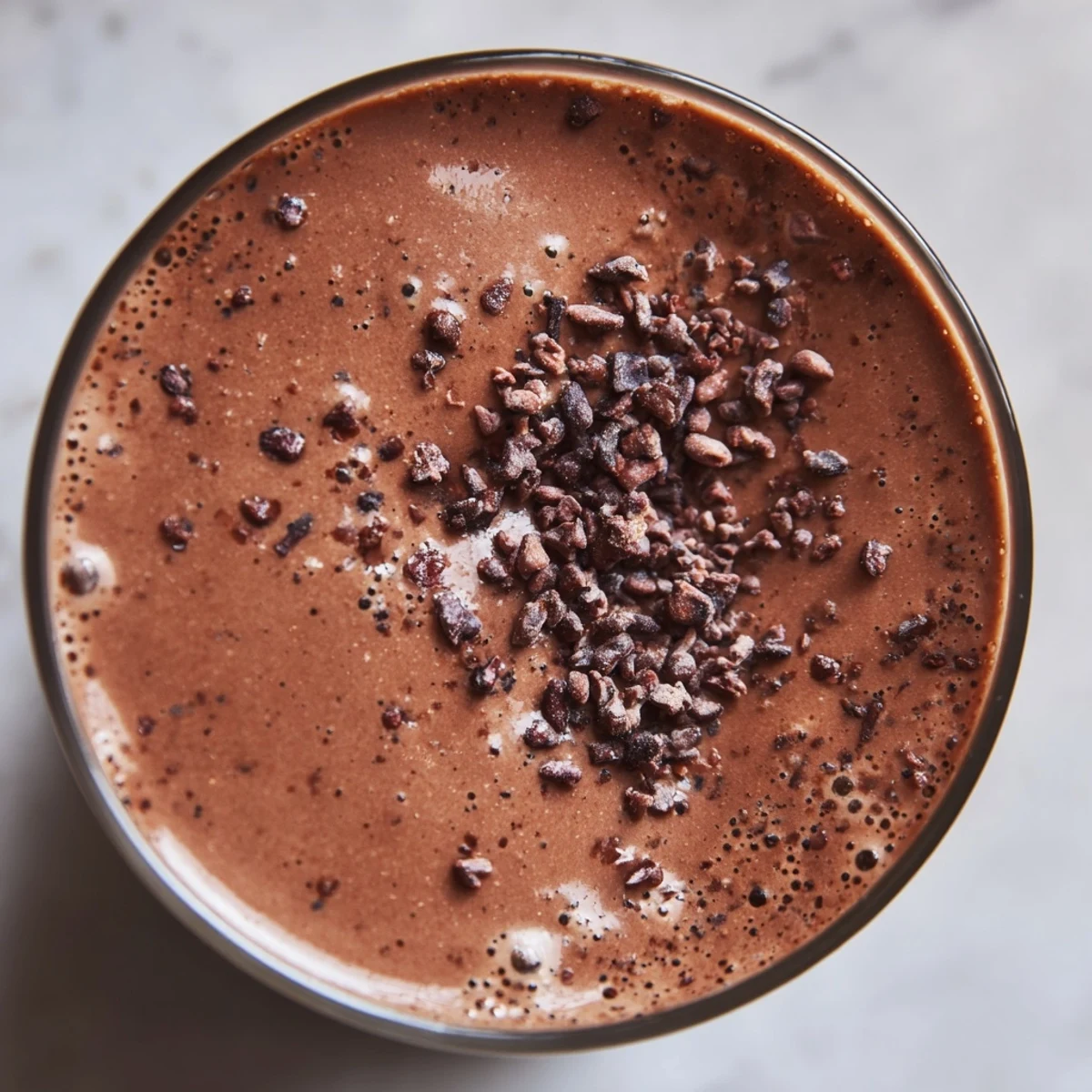 Close-up of a blender making Avocado Cacao Smoothie, showing the thick, velvety chocolate texture ready for a healthy breakfast.