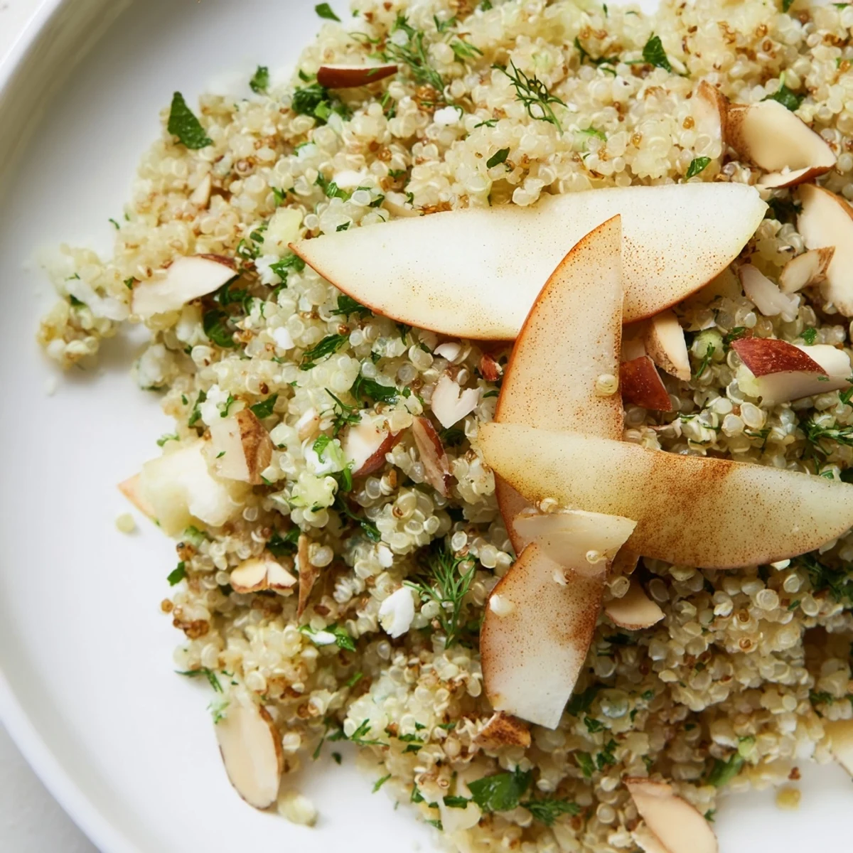 Close up of Quinoa and Herb Pilaf featuring glazed apples and vibrant green herbs for a sweet-savory meal.