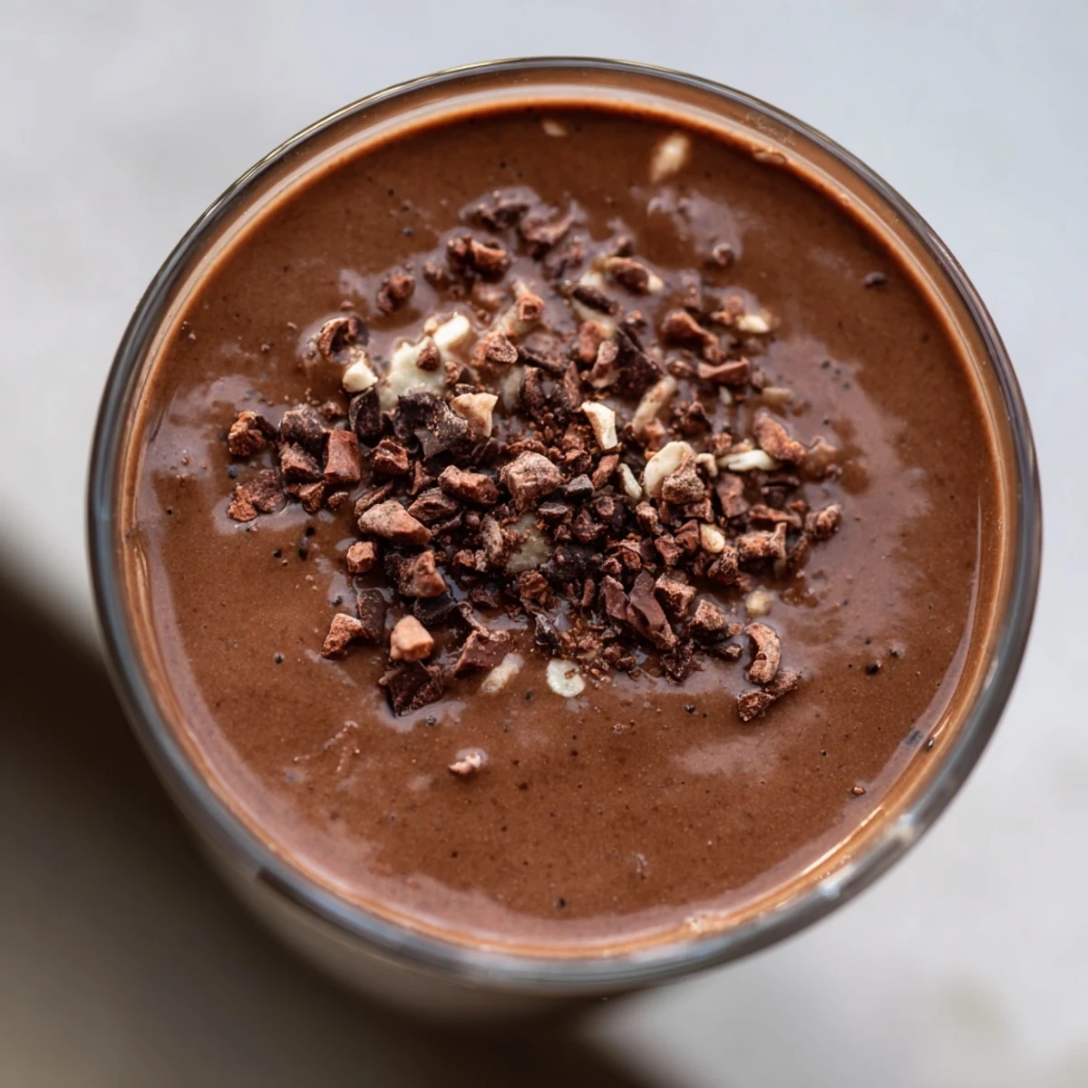 Creamy Miso Glazed Avocado Cacao Smoothie poured into a glass, showcasing a rich chocolatey hue and healthy avocado fats.