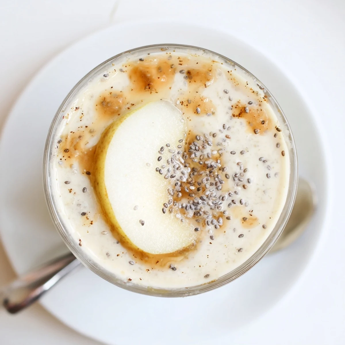 Chilled Miso Glazed Pear Ginger Smoothie garnished with granola and chia seeds alongside whole pears and ginger.