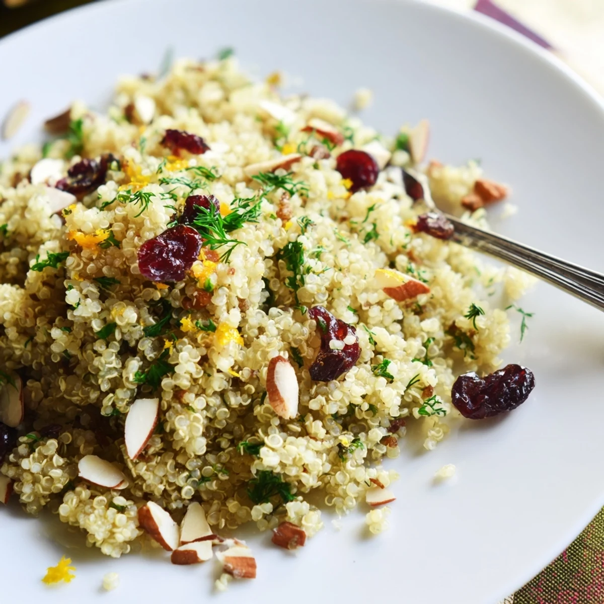 Golden quinoa and herb pilaf with citrus finished with toasted almonds and cranberries, ready for a Mediterranean dinner plate.
