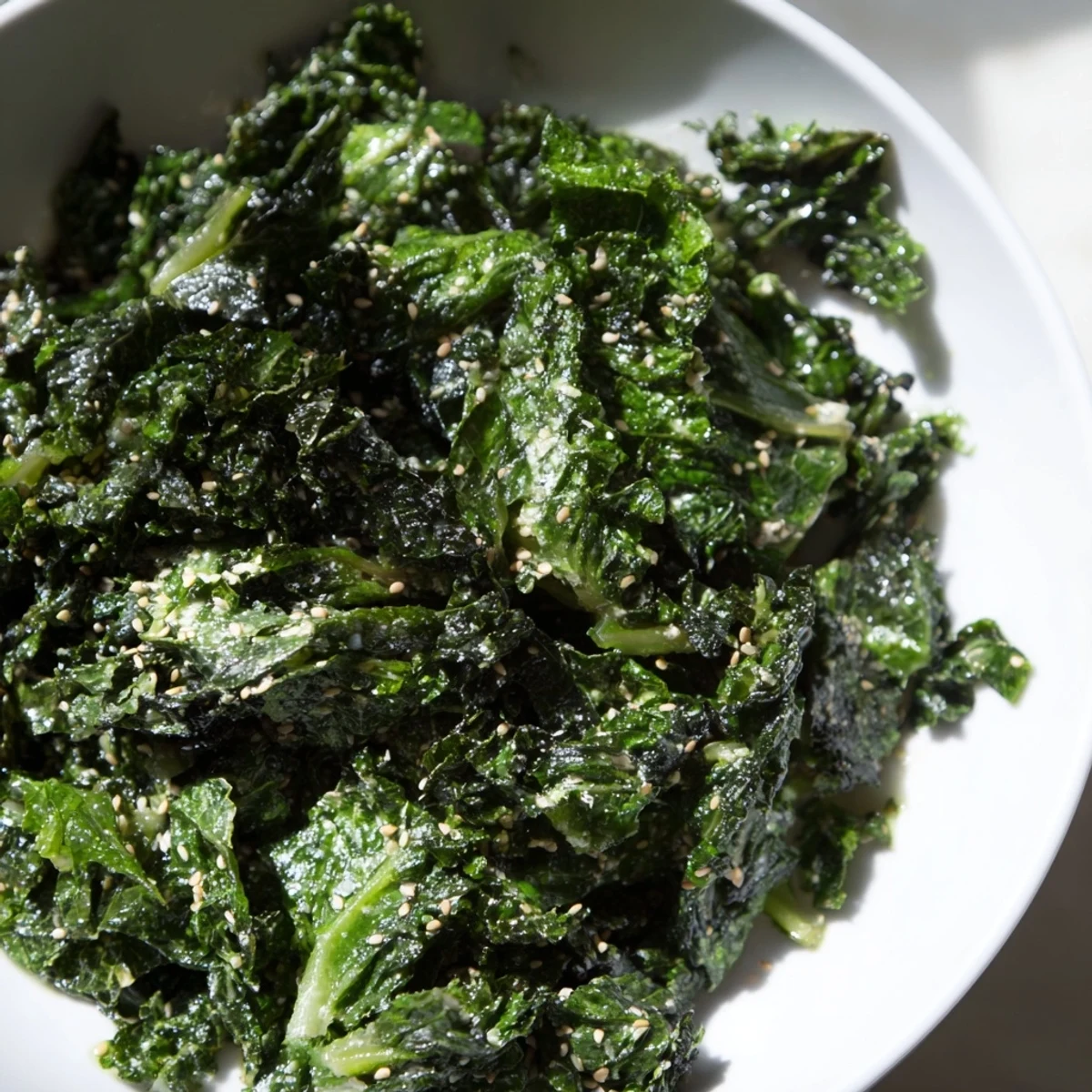 A serving of Braised Winter Greens with Warming Miso Glaze in a rustic ceramic bowl, perfect as a comforting side dish for a chilly evening meal.