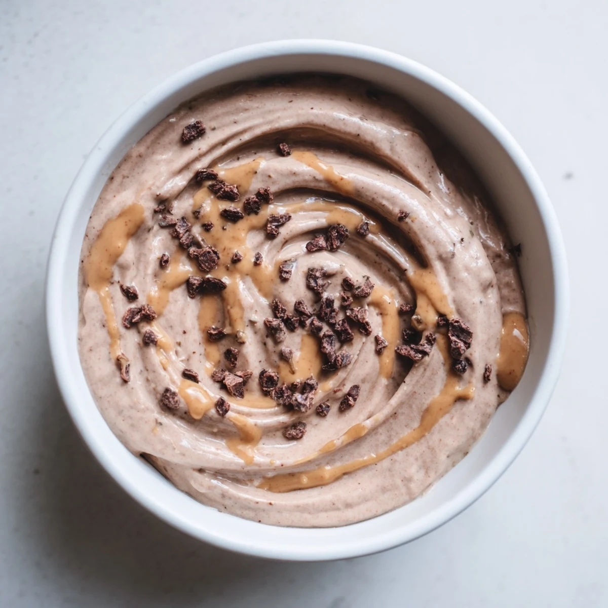 Scoops of rich Immune Boosting Cocoa Banana Nice Cream served with orange slices for a vibrant, healthy dessert.