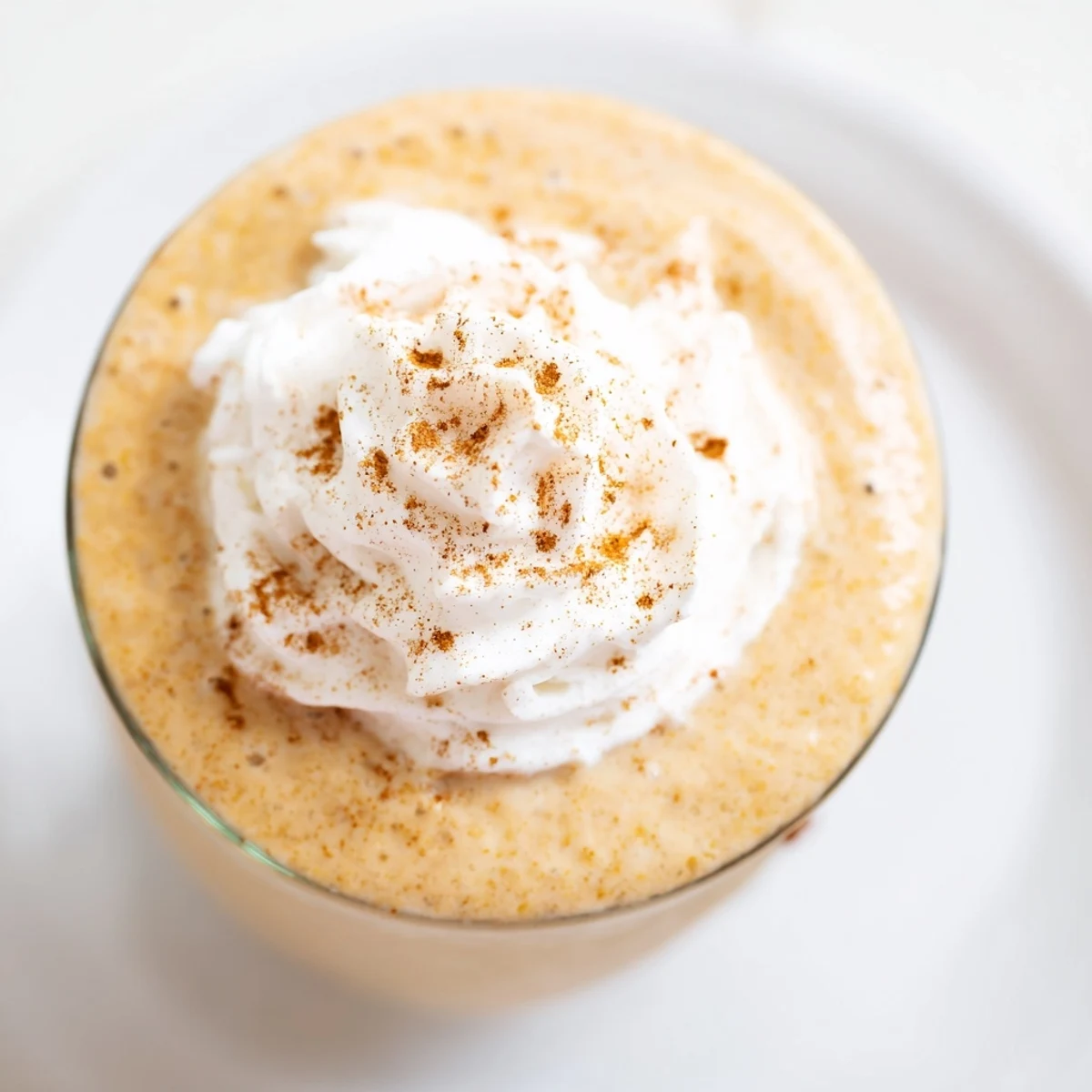 Healthy pumpkin spice smoothie with frozen banana, maple syrup, and warm spices, offering a nutritious and comforting beverage option.