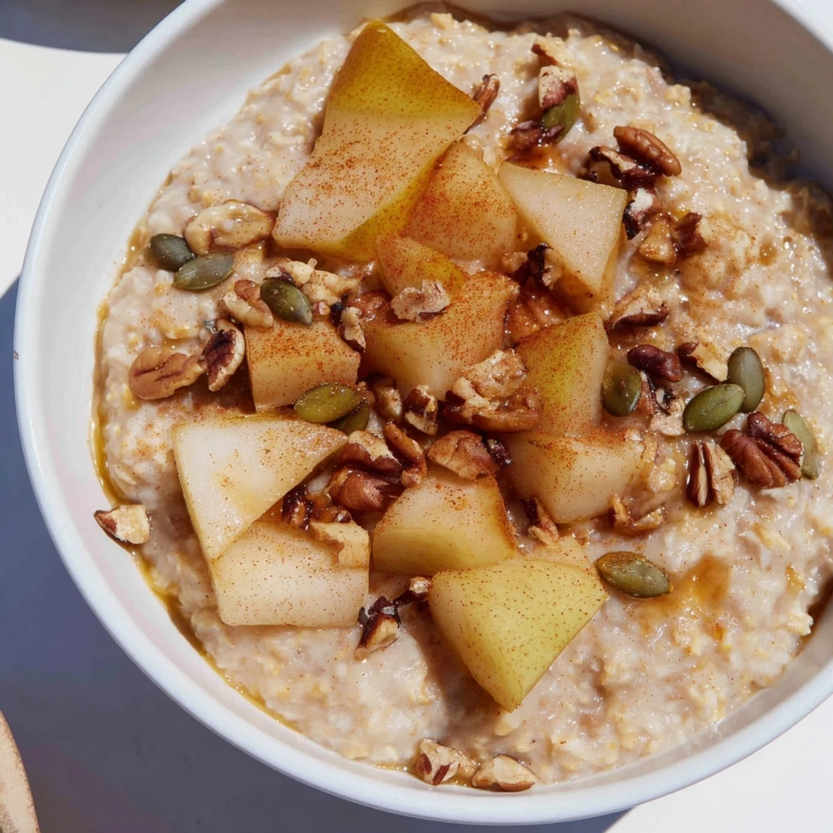 Close-up of Smoky Warming Spiced Pear Porridge, highlighting the tender diced pears and creamy oats infused with cinnamon and smoked paprika.
