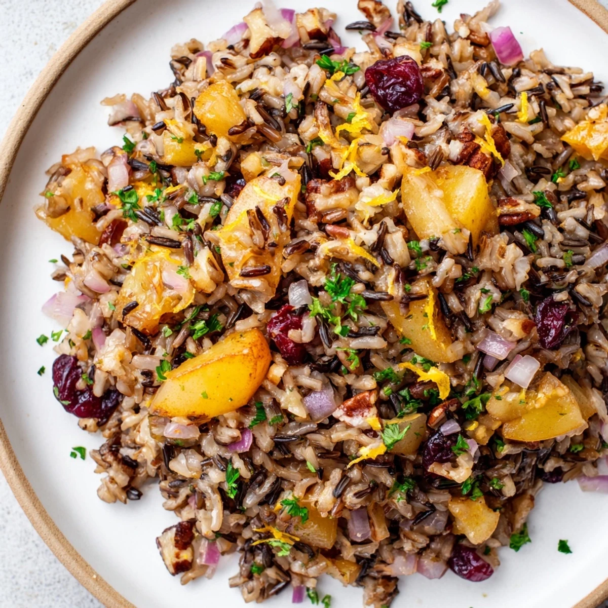 Steaming plate of Wild Rice Citrus Pilaf with Warm Pear and Spiced Apple, highlighting sautéed pears, spiced apples, and vibrant orange zest.