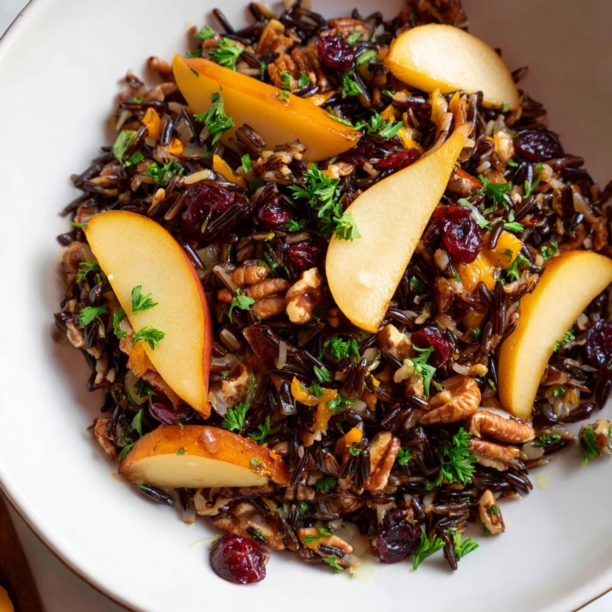Wild Rice Citrus Pilaf with Warm Pear and Spiced Apple served warm in a white dish, showing tender grains and colorful fruit slices.