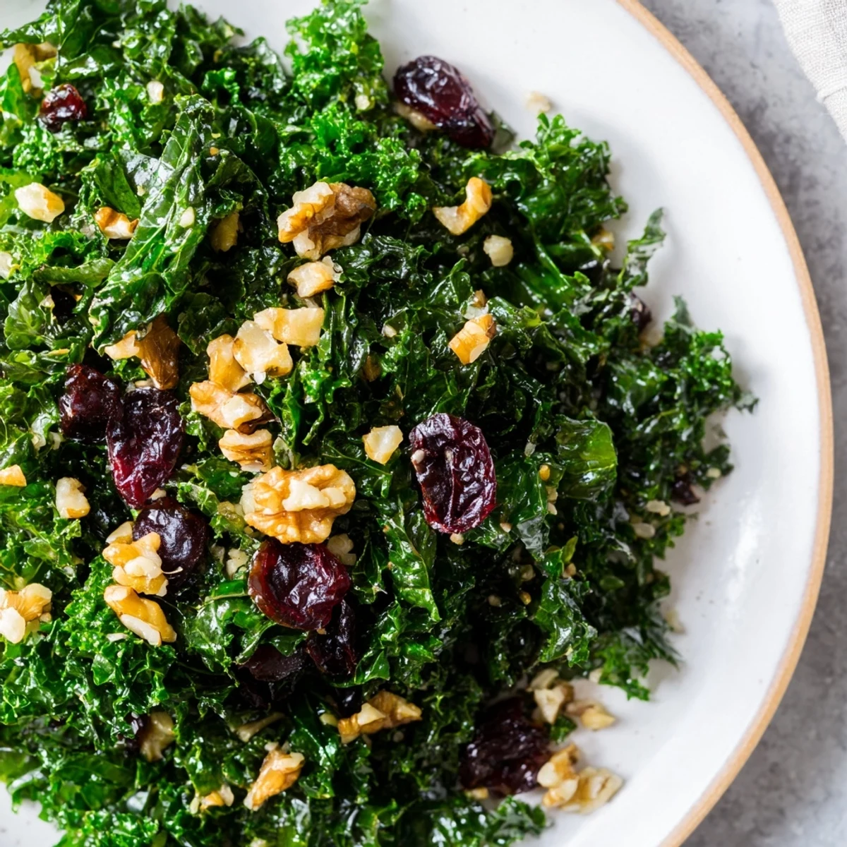 Garlic Sautéed Kale with Cranberries served warm from a skillet, garnished with toasted walnuts for a nutty crunch.