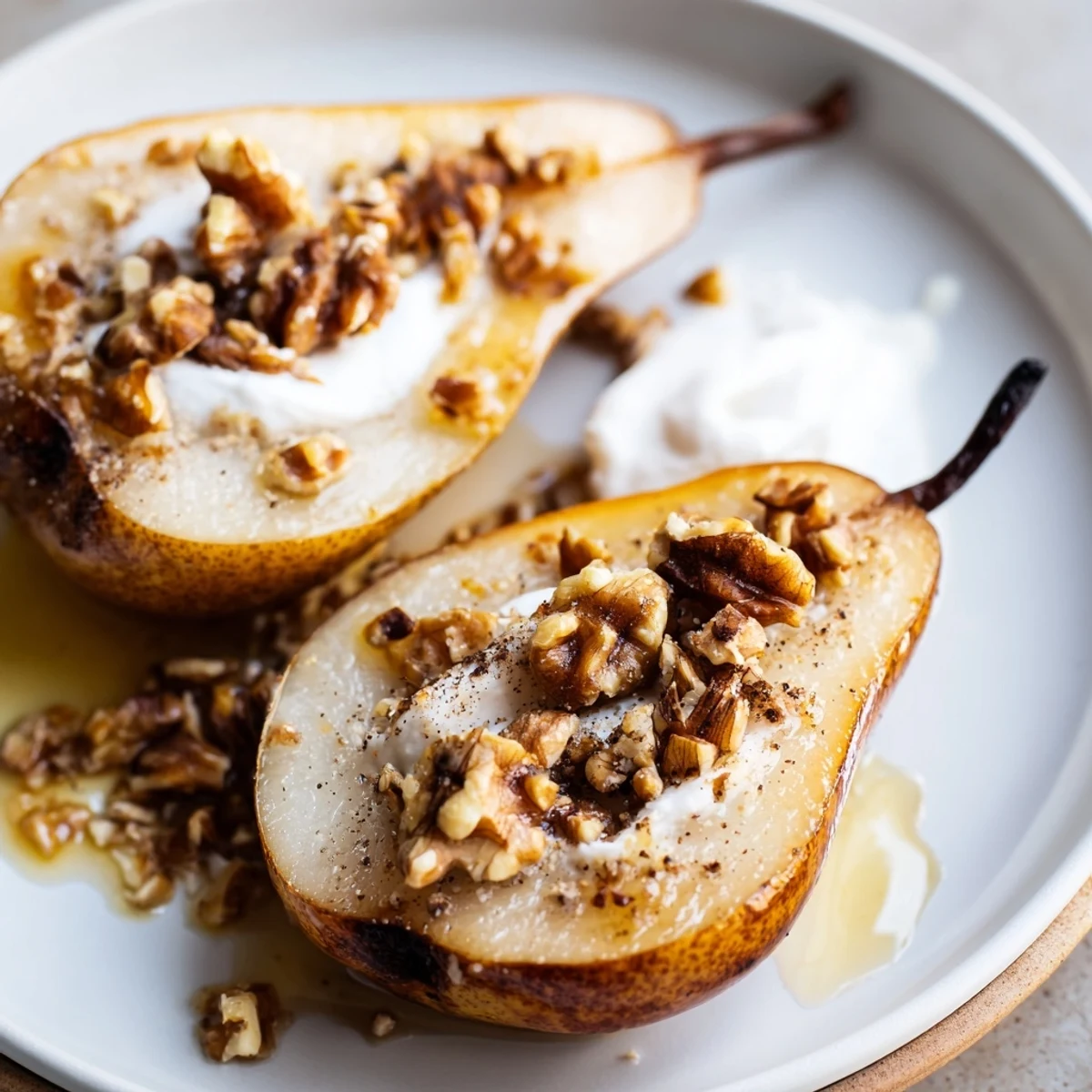 Freshly baked Ginger Scented Baked Pears topped with chopped pecans and a scoop of vanilla ice cream, served warm.