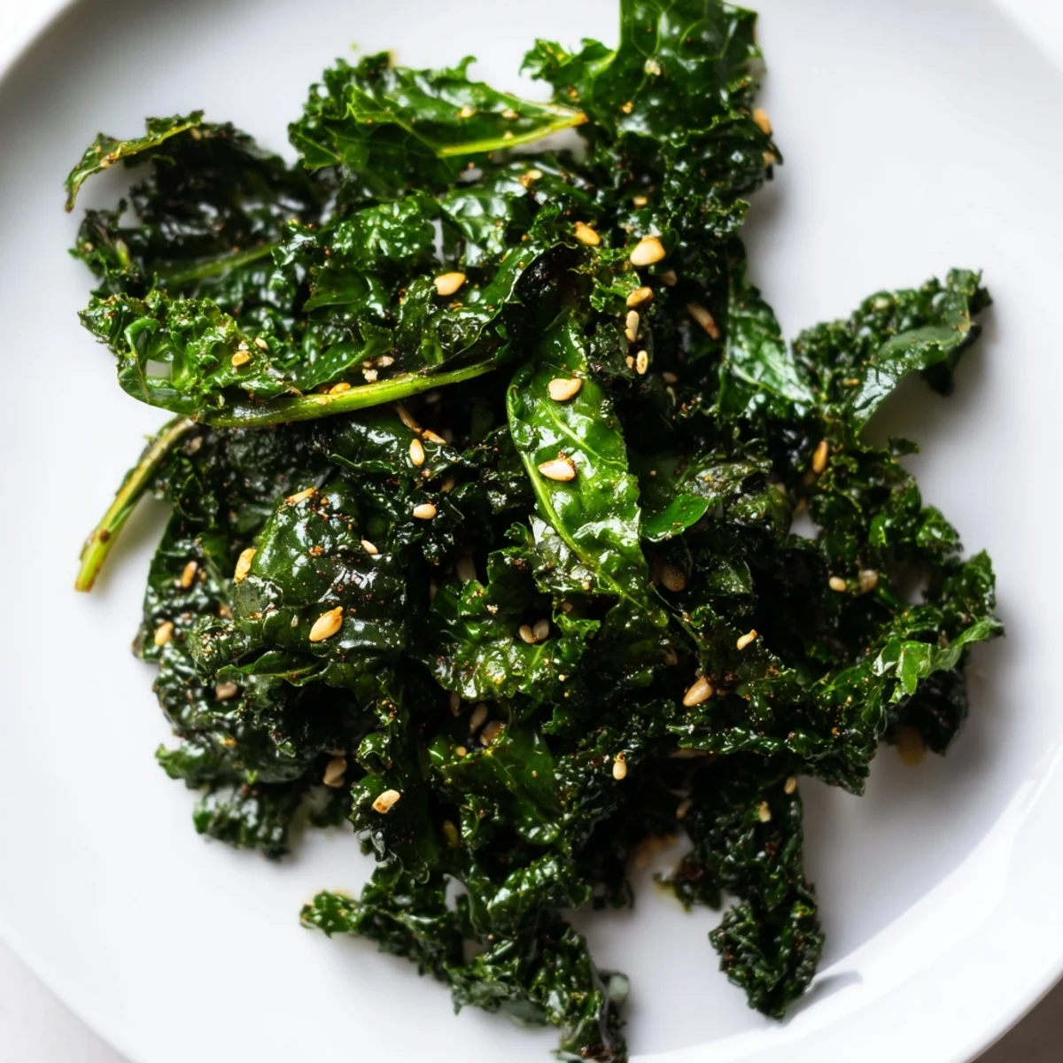 A close-up of Smoky Miso Kale Sauté showing wilted green leaves with a glossy miso glaze.