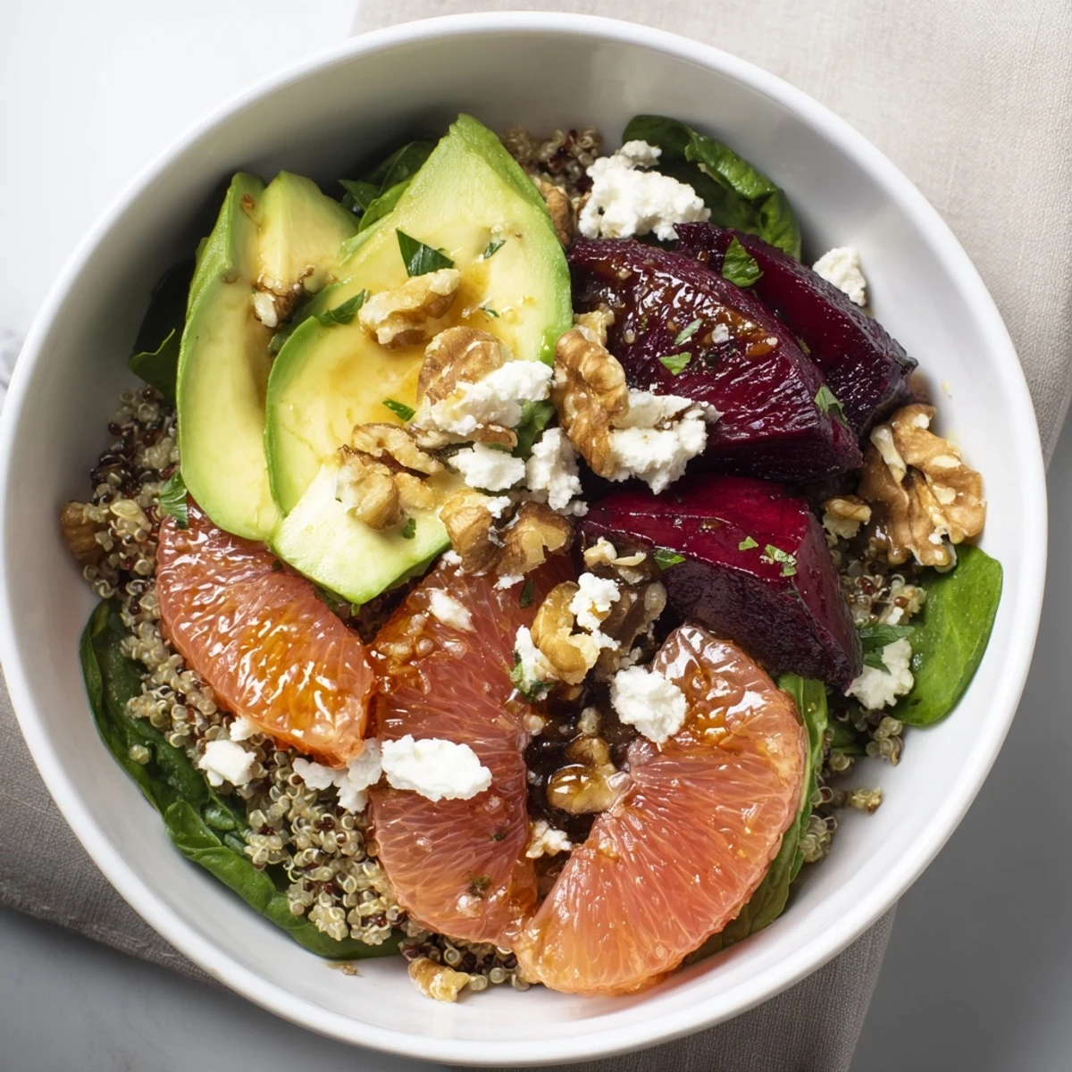 Close-up of the Roasted Beet and Citrus Grain Bowl topped with creamy avocado slices and fresh herbs.