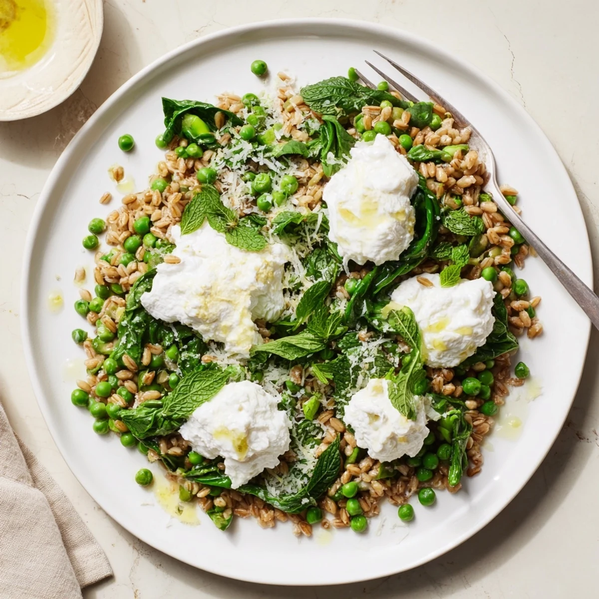 Overhead view of Lemon Ricotta Farro With Spring Herbs garnished with mint, parsley, and a lemon wedge.