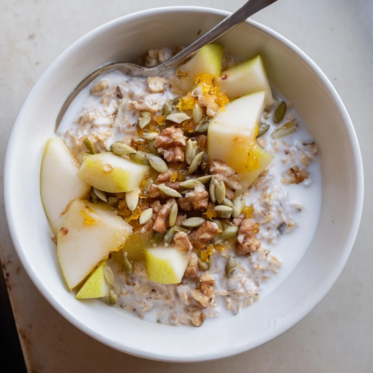 Pear Ginger Overnight Oats Bowl with warm spices and a sprinkle of crystallized ginger.