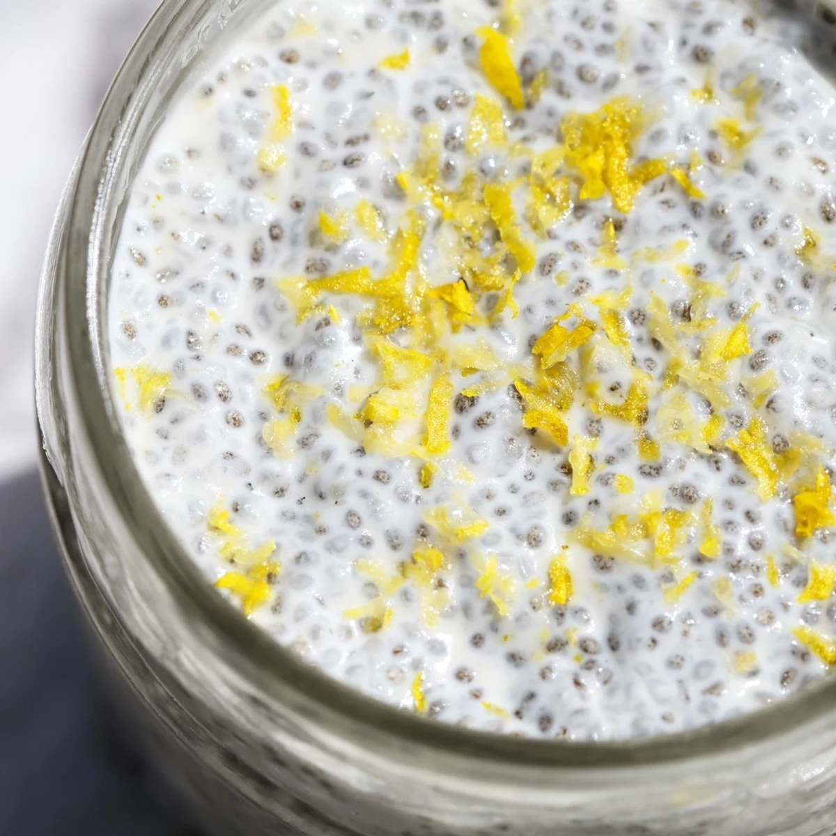 Thick and creamy lemon poppy seed chia pudding breakfast bowl with poppy seed speckles throughout