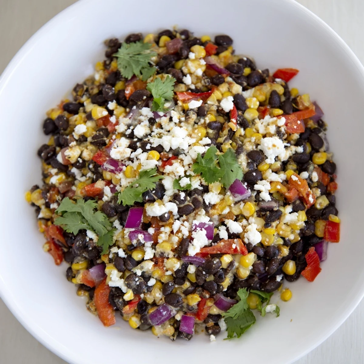 Golden smoky chipotle black bean skillet topped with fresh cilantro and crumbled white cheese