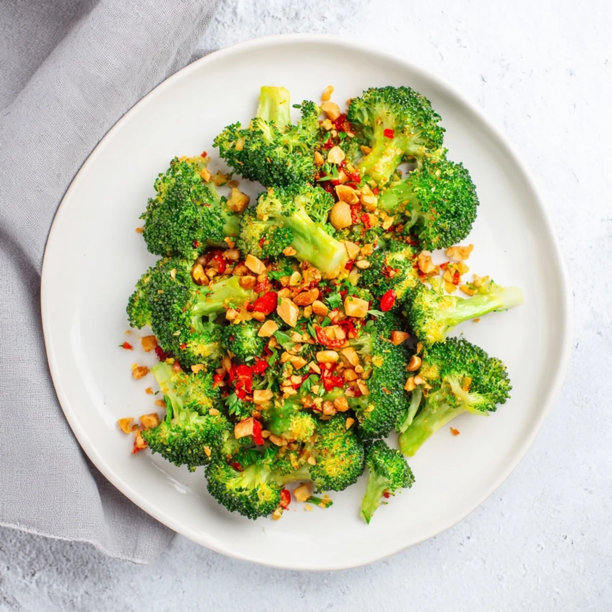 Vegan roasted broccoli side dish finished with aromatic garlic chili almonds and bright citrus notes