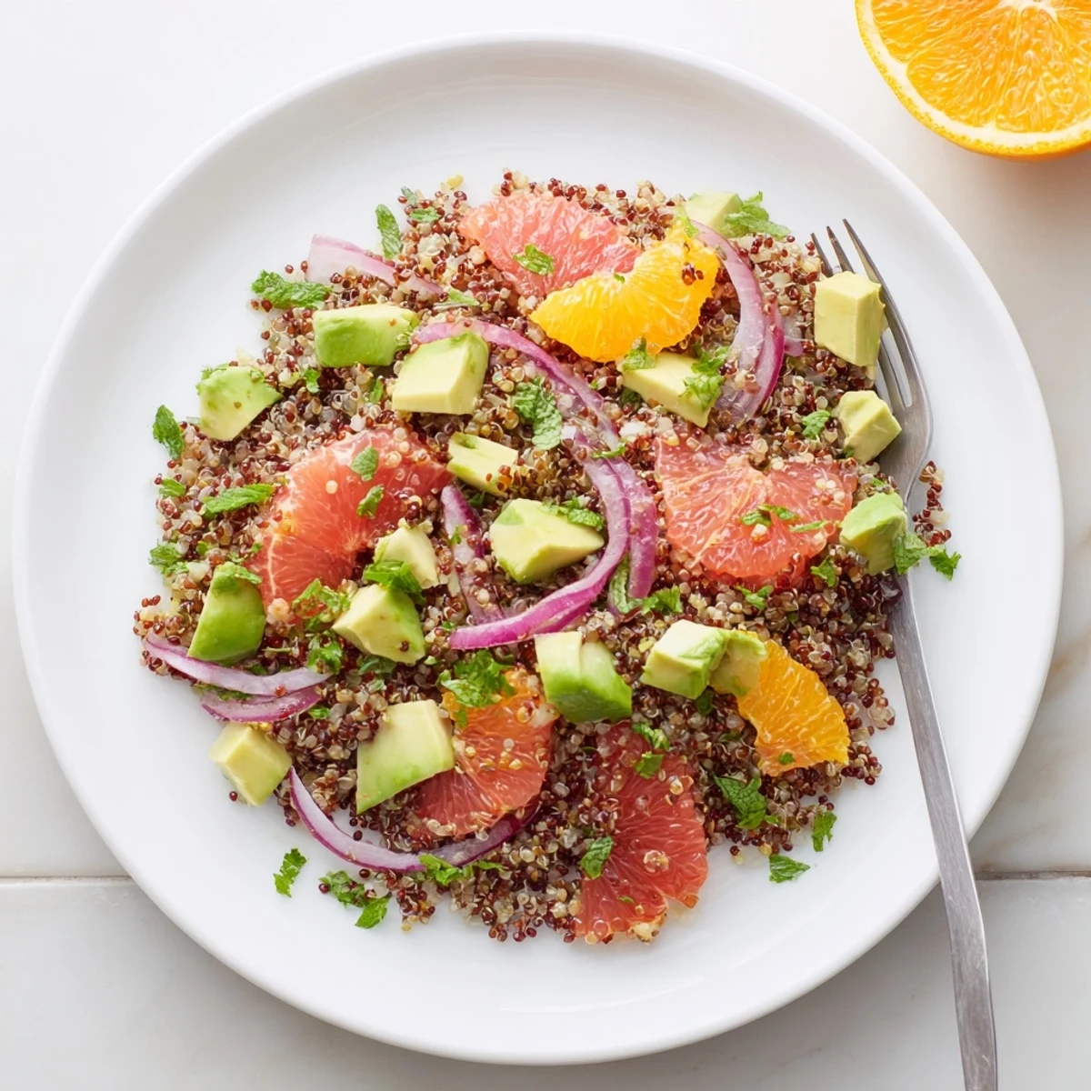 Bright citrus avocado quinoa salad bowl featuring orange segments, diced avocado, and fresh cilantro tossed in zesty lime dressing