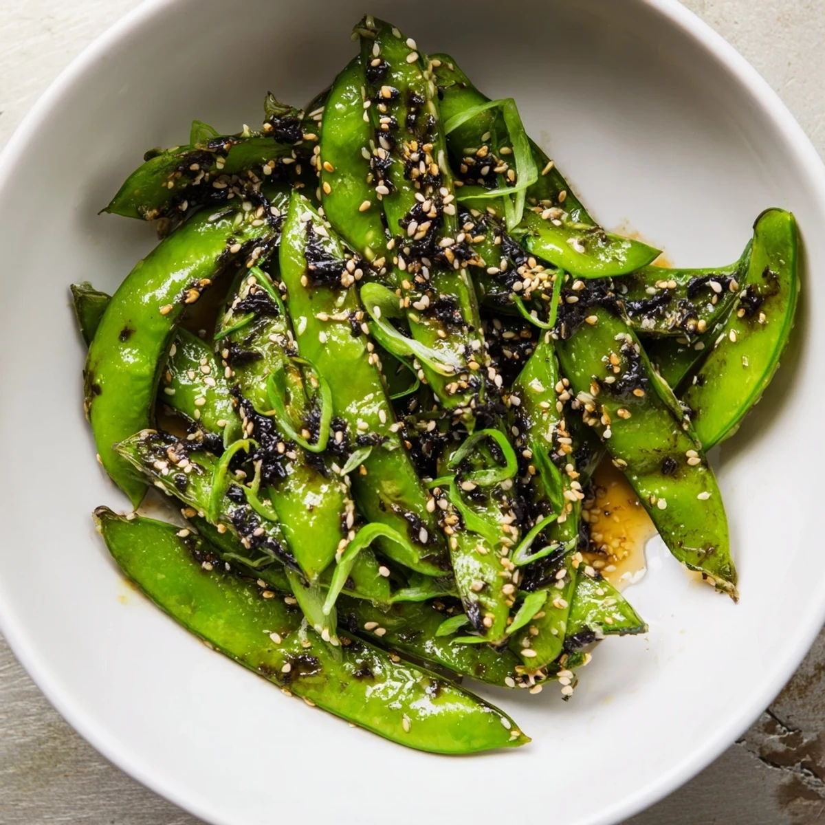 Oven-roasted snap peas tossed in crispy sesame seed clusters with a sweet glaze