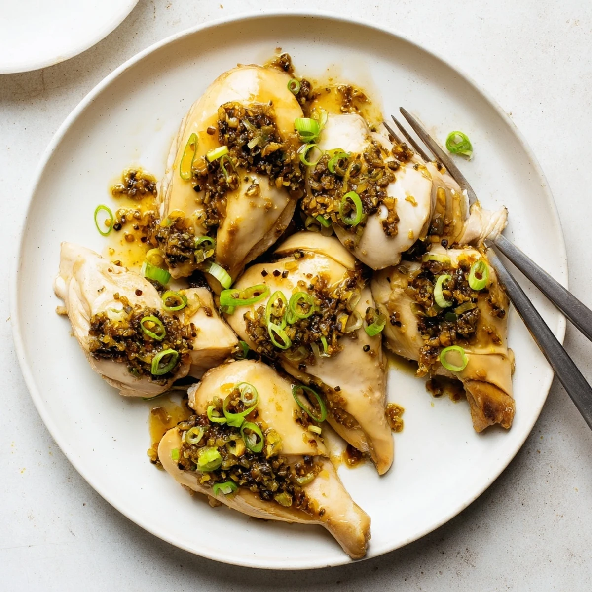 Chinese-style ginger scallion steamed chicken thigh served with rice and vibrant scallion topping