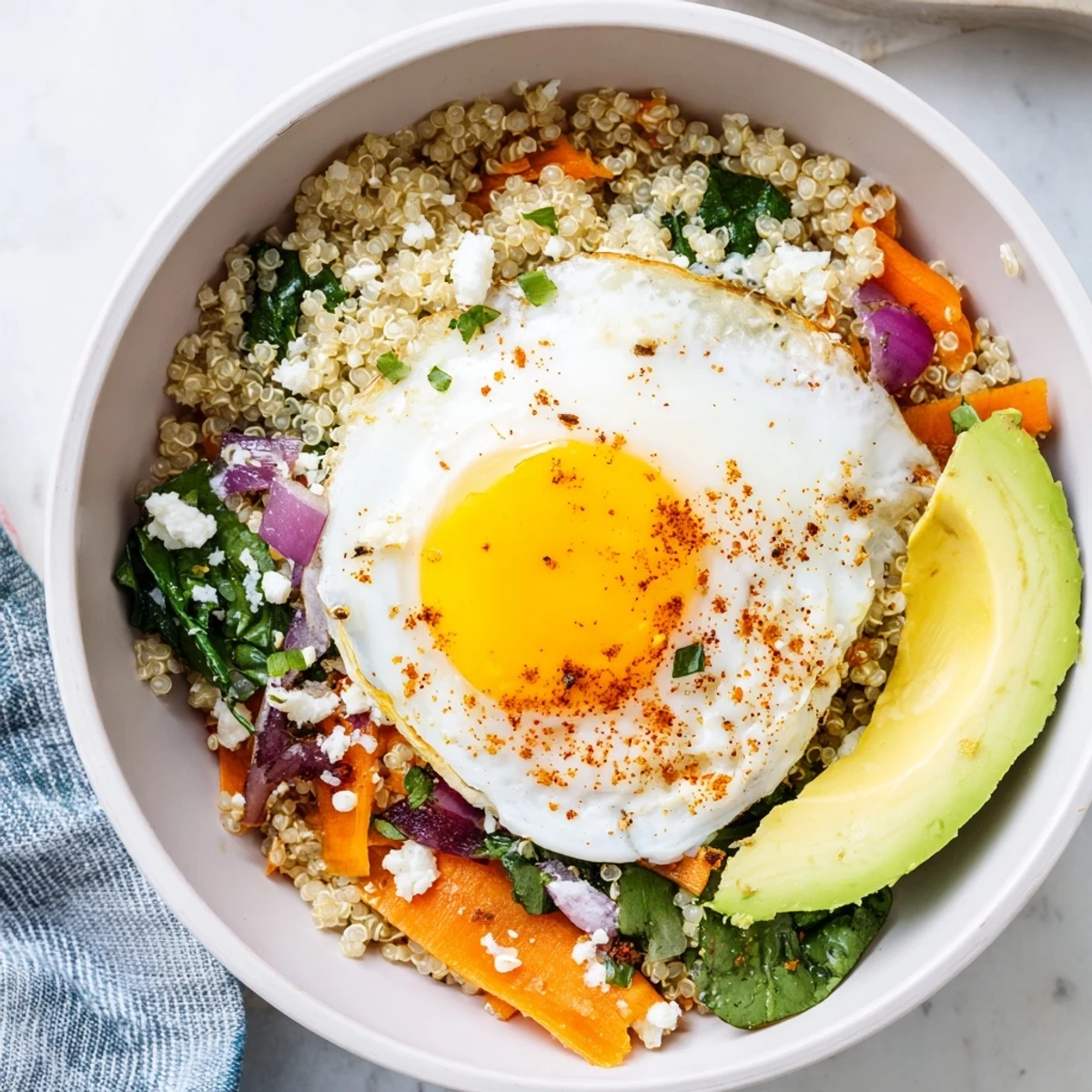 Warm Savory Carrot and Spinach Quinoa Breakfast Bowl with fluffy grains and avocado