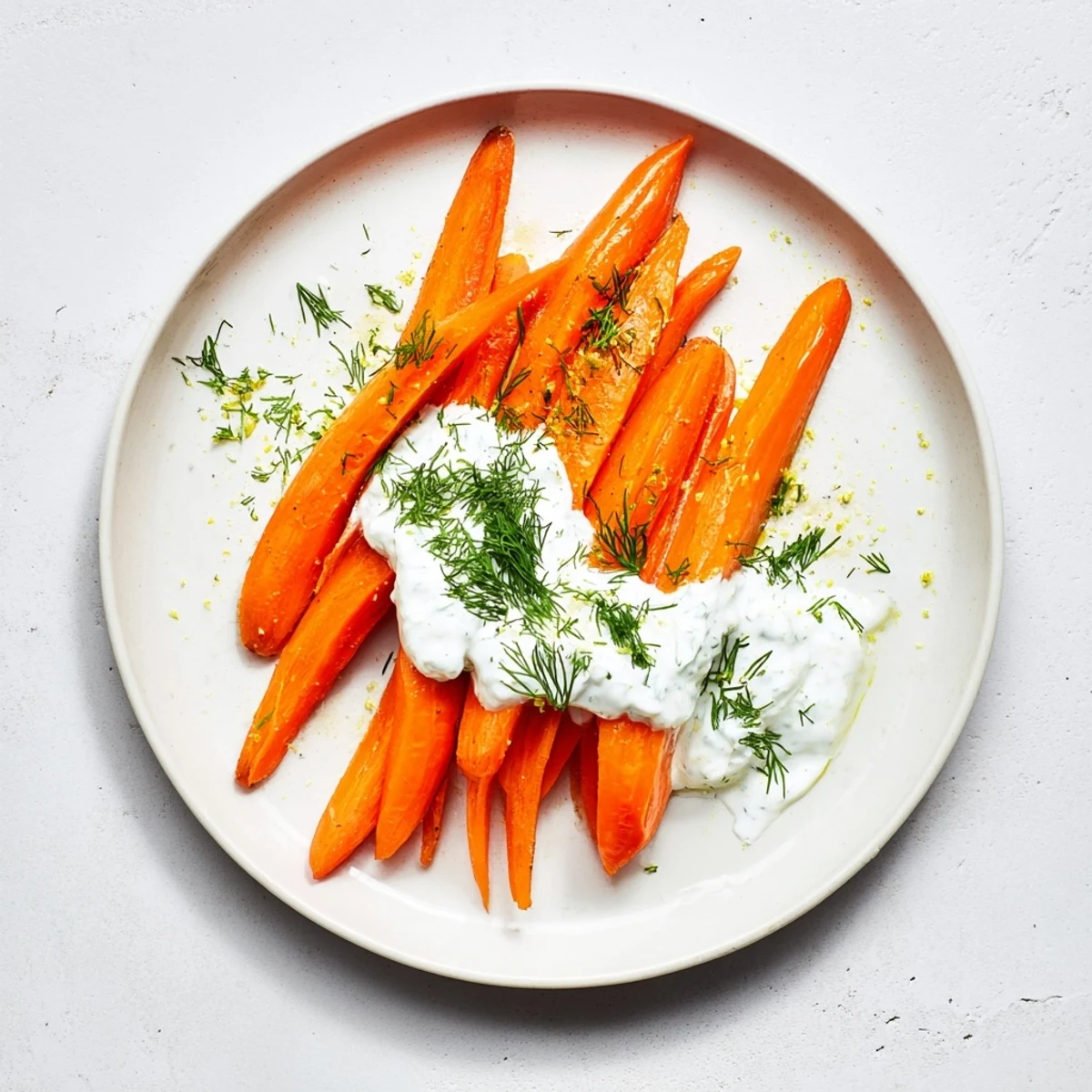 Tender Mediterranean-style roasted carrots arranged on a platter with tangy herbed yogurt dipping sauce