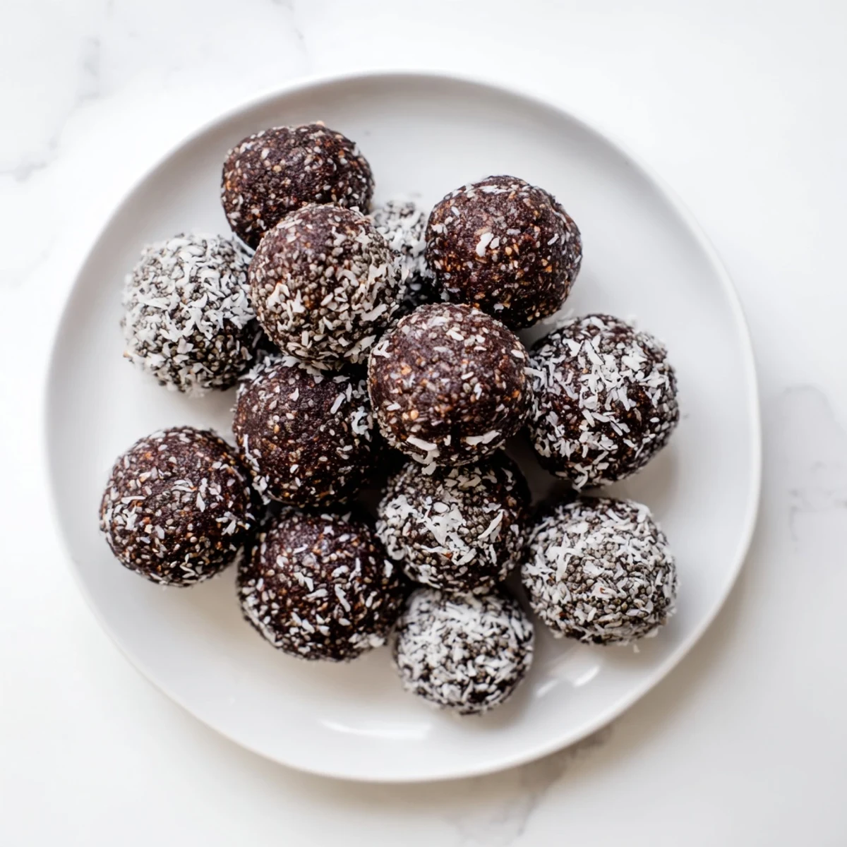 Rich chocolate cocoa coconut cashew chia bliss balls rolled in shredded coconut
