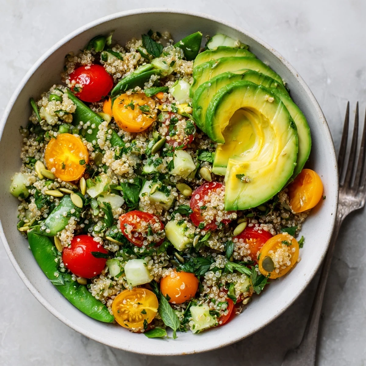 Colorful grain bowl with fluffy citrus herb quinoa, crisp snap peas, and refreshing orange lemon vinaigrette