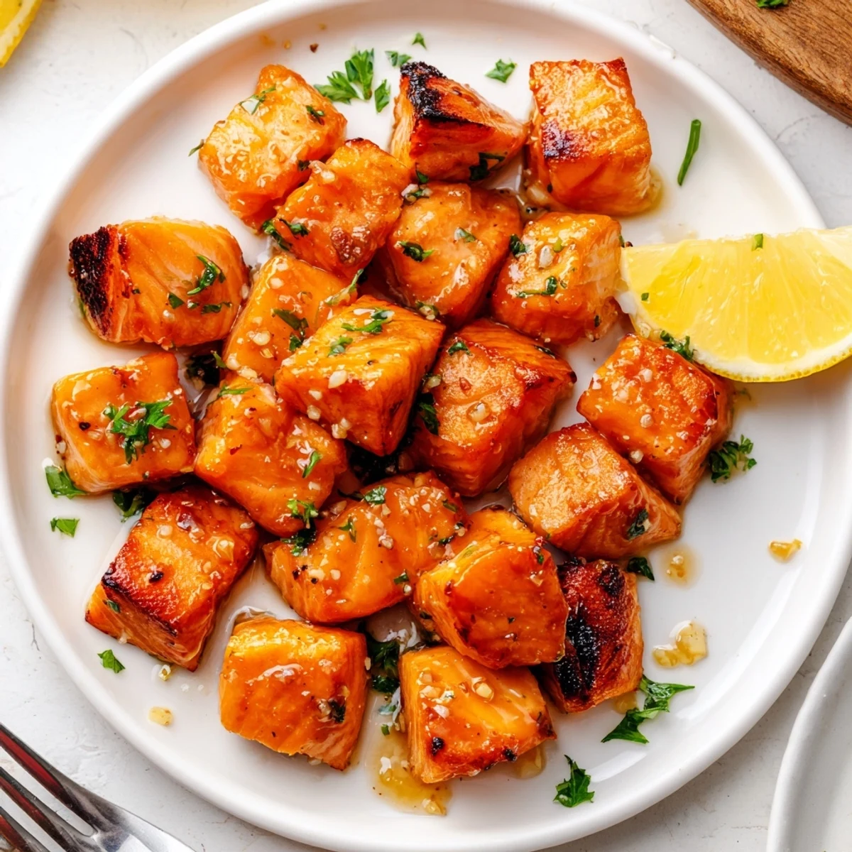 Lemon Garlic Glazed Salmon Bites glistening with lemon glaze, garnished with parsley.
