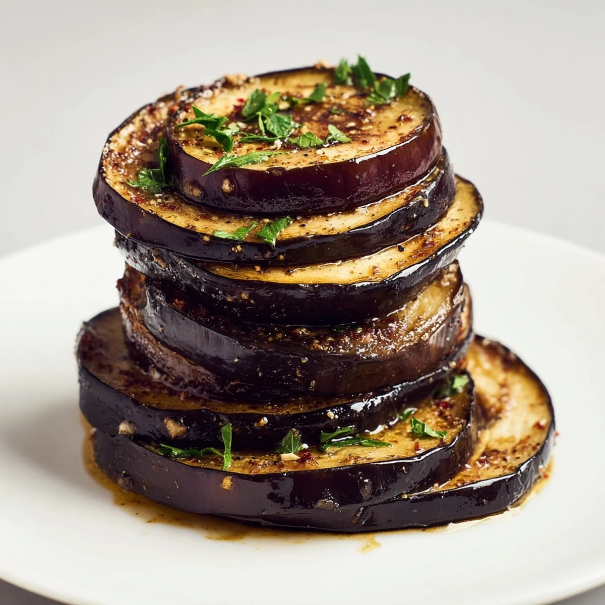 Smoky Roasted Eggplant Slices glistening with olive oil, golden edges and herbs
