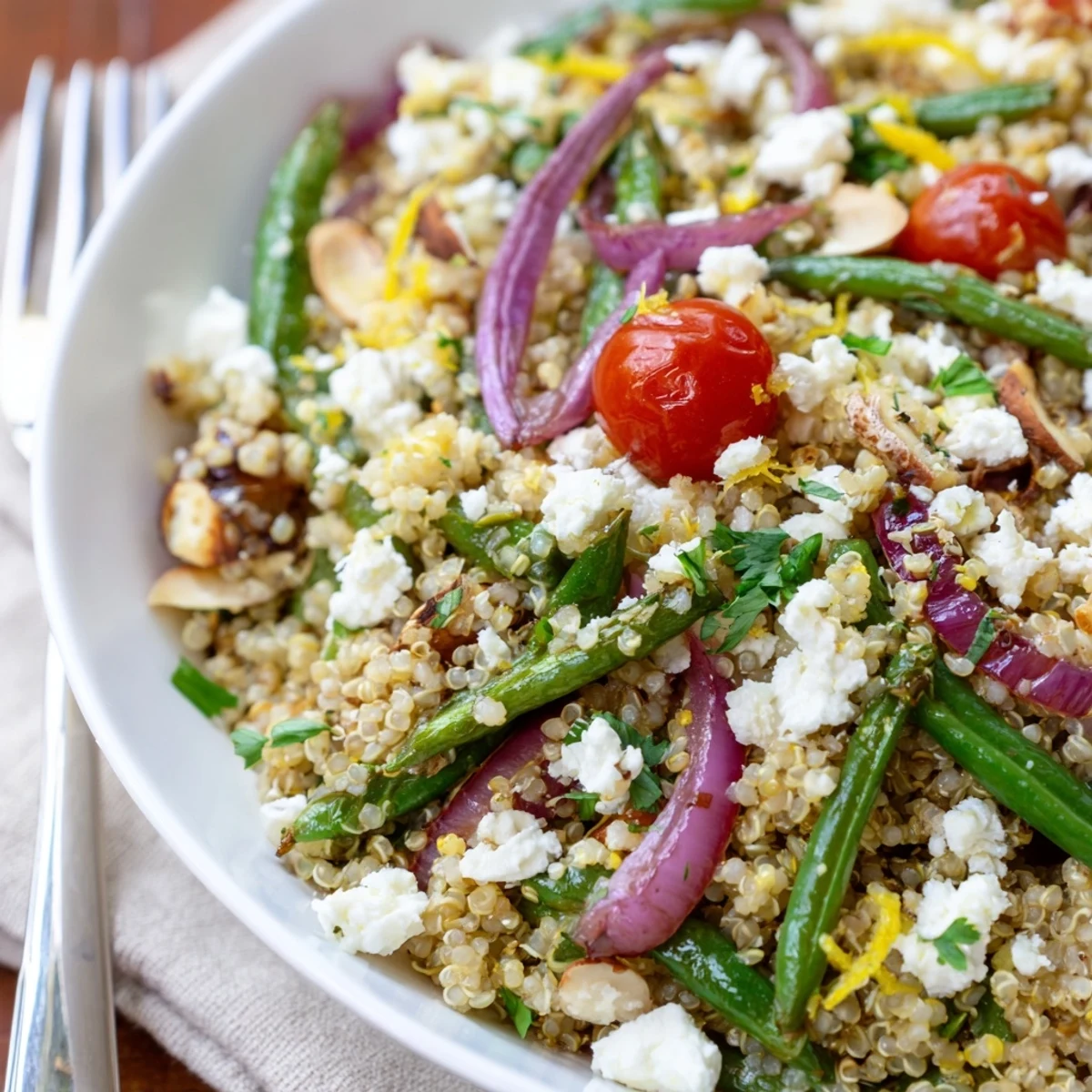A bowl of warm quinoa and roasted green bean salad, crunchy almonds