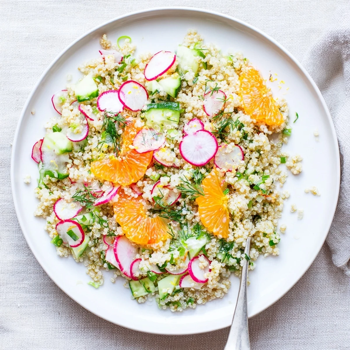 Mediterranean-style quinoa salad featuring fluffy grains, grapefruit wedges, crisp radishes, and chopped parsley