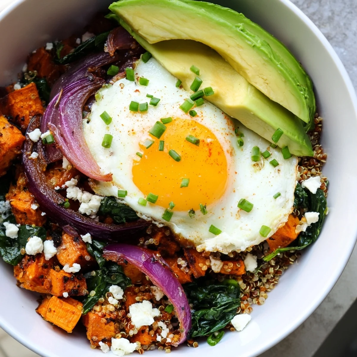 Colorful morning meal featuring fluffy quinoa seasoned with smoked paprika alongside tender roasted sweet potatoes and fresh greens