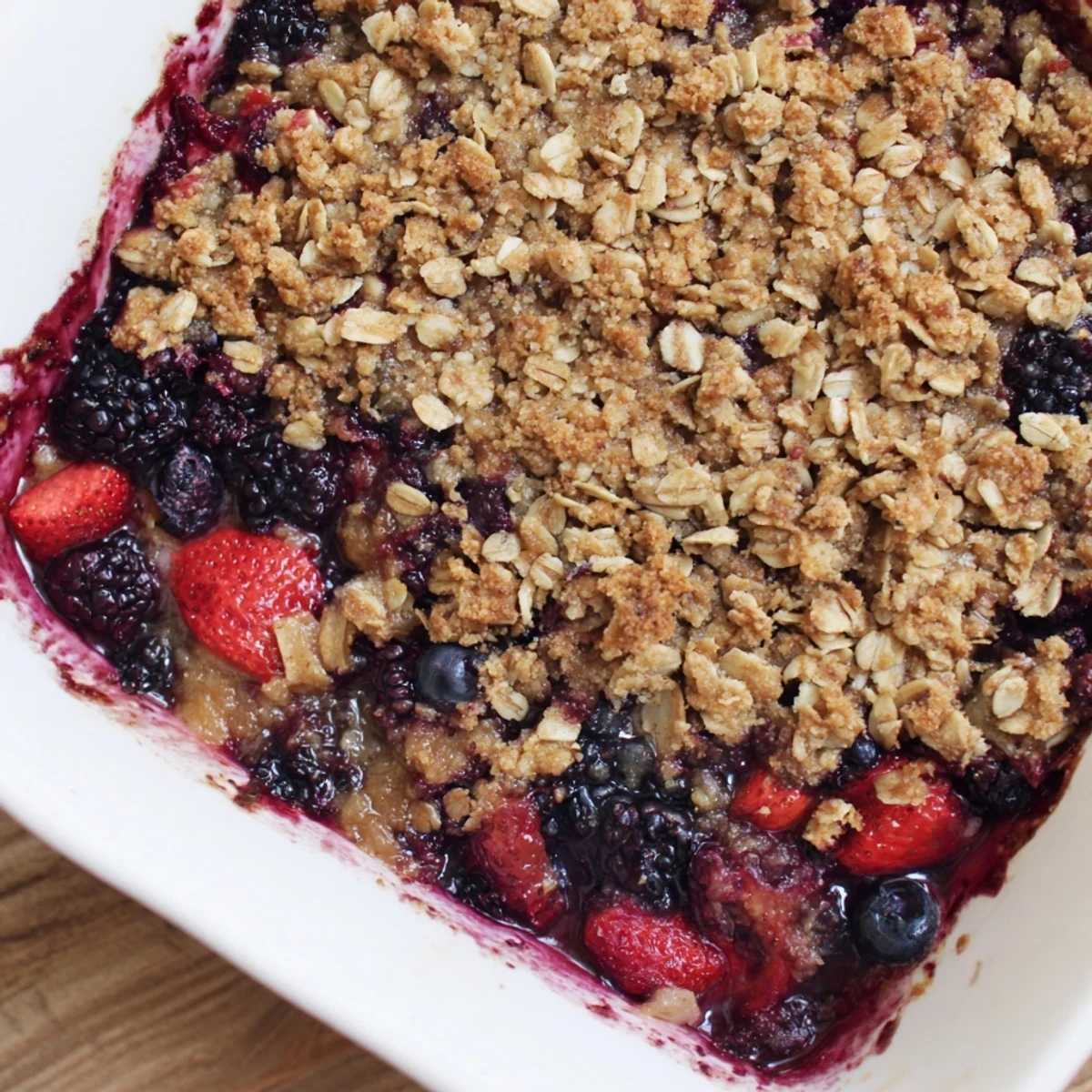 Homemade vanilla maple berry crisp with juicy mixed fruit filling and golden brown streusel layer
