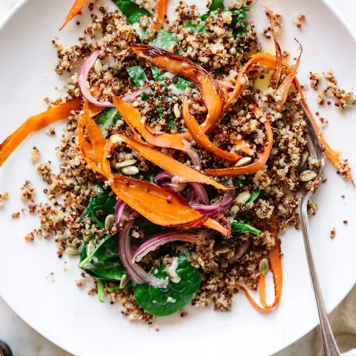 A cozy bowl of Warm Quinoa and Roasted Carrot Ribbon Salad with caramelized carrots.