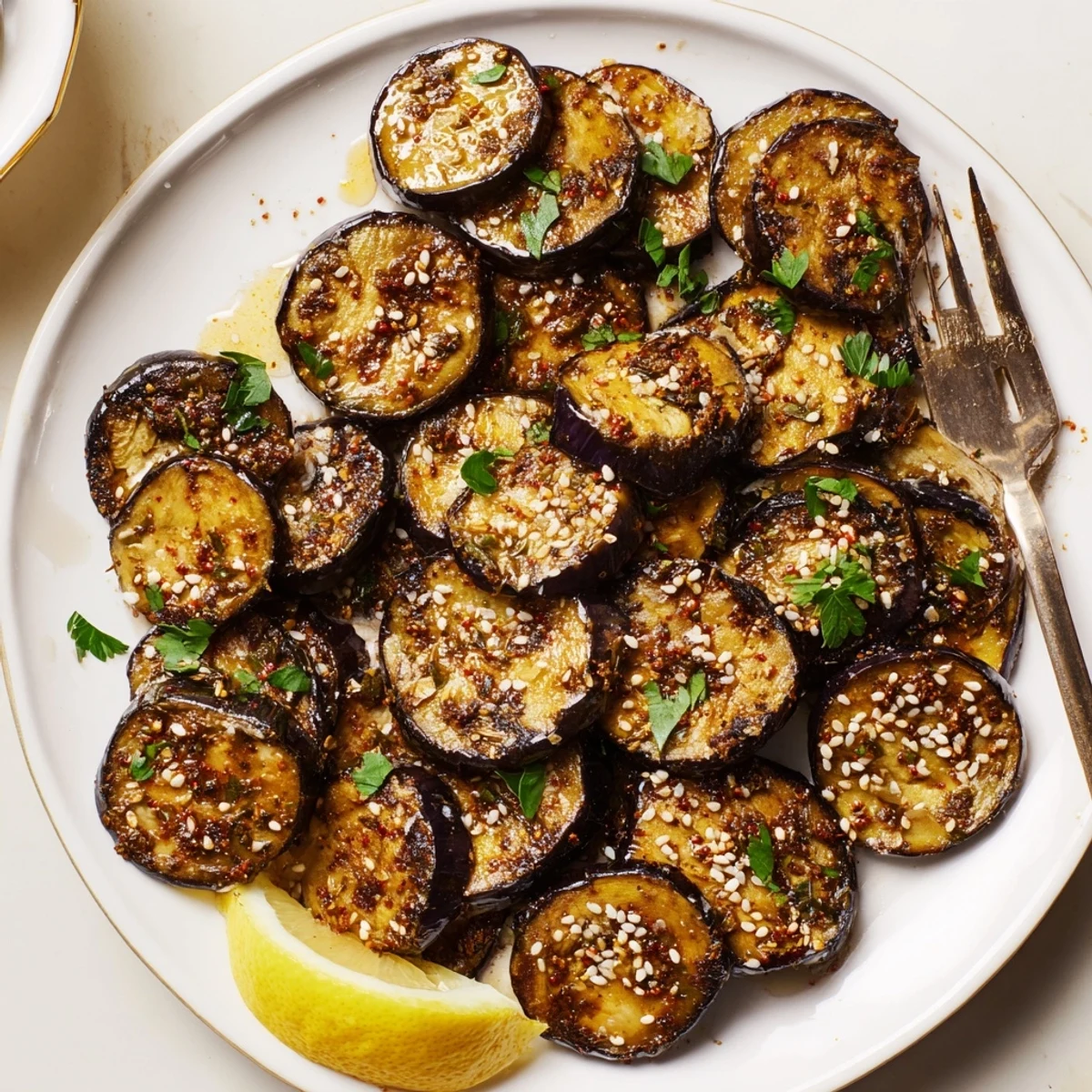 Smoky Roasted Eggplant Coins arranged on a platter, golden edges and parsley.