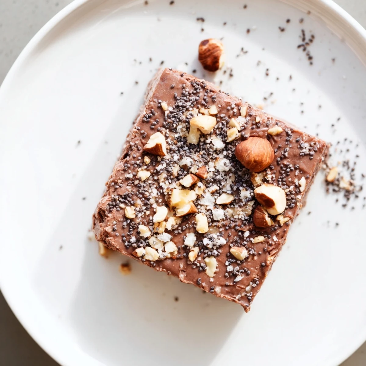 Cocoa Hazelnut Coconut Chia Treat squares chilled on parchment, crunchy hazelnut topping.