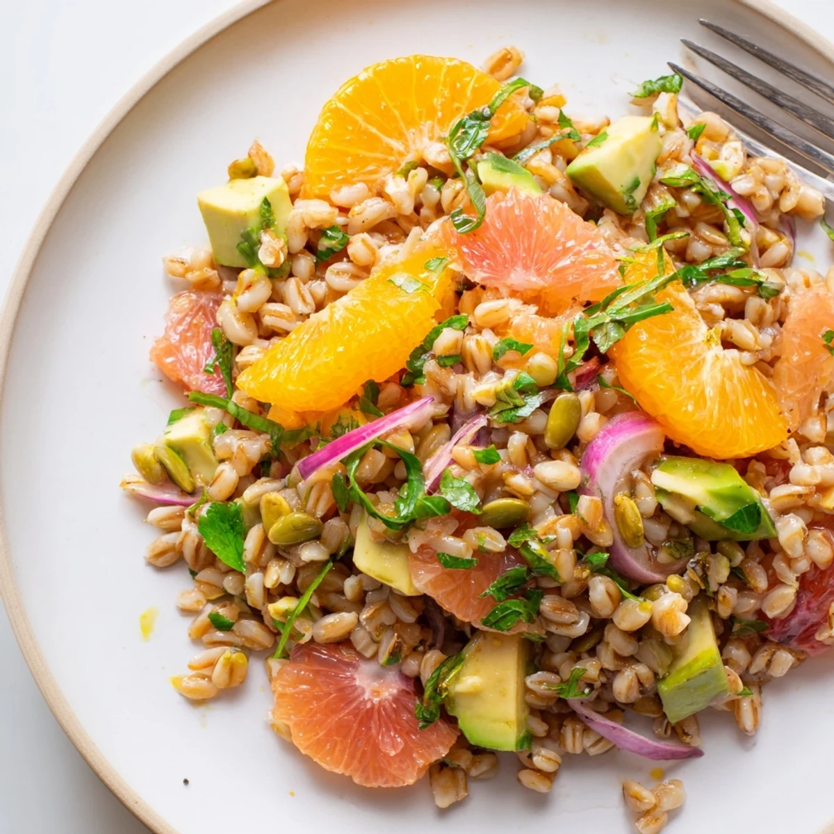 Creamy avocado and bright citrus crown this hearty Citrus Herb Farro and Avocado Salad in a rustic bowl