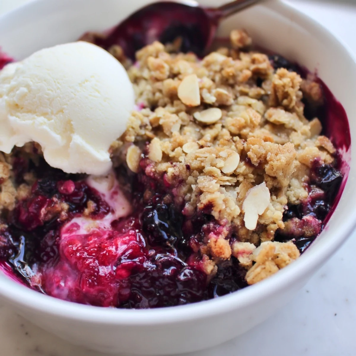 Warm vanilla berry almond crumble topped with a crunchy golden oat almond crust