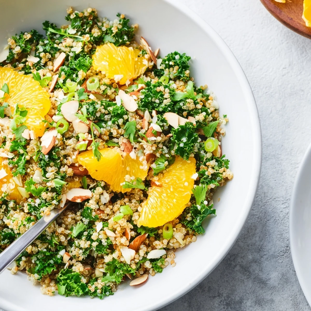 Fresh citrus herb quinoa and kale salad served with grapefruit and orange segments.