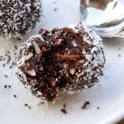Cocoa Almond Coconut Chia Treat rolled into glossy chocolatey bites beside espresso
