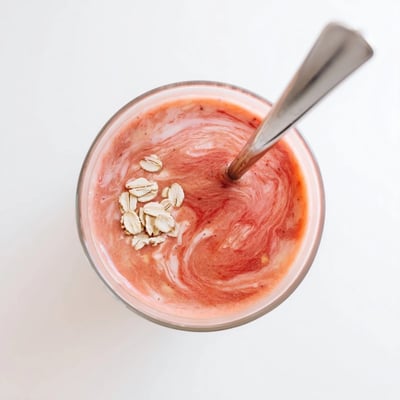 Vibrant peach raspberry oat smoothie blended until smooth with oats for a nutritious breakfast