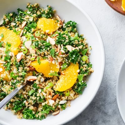 Fresh citrus herb quinoa and kale salad served with grapefruit and orange segments.